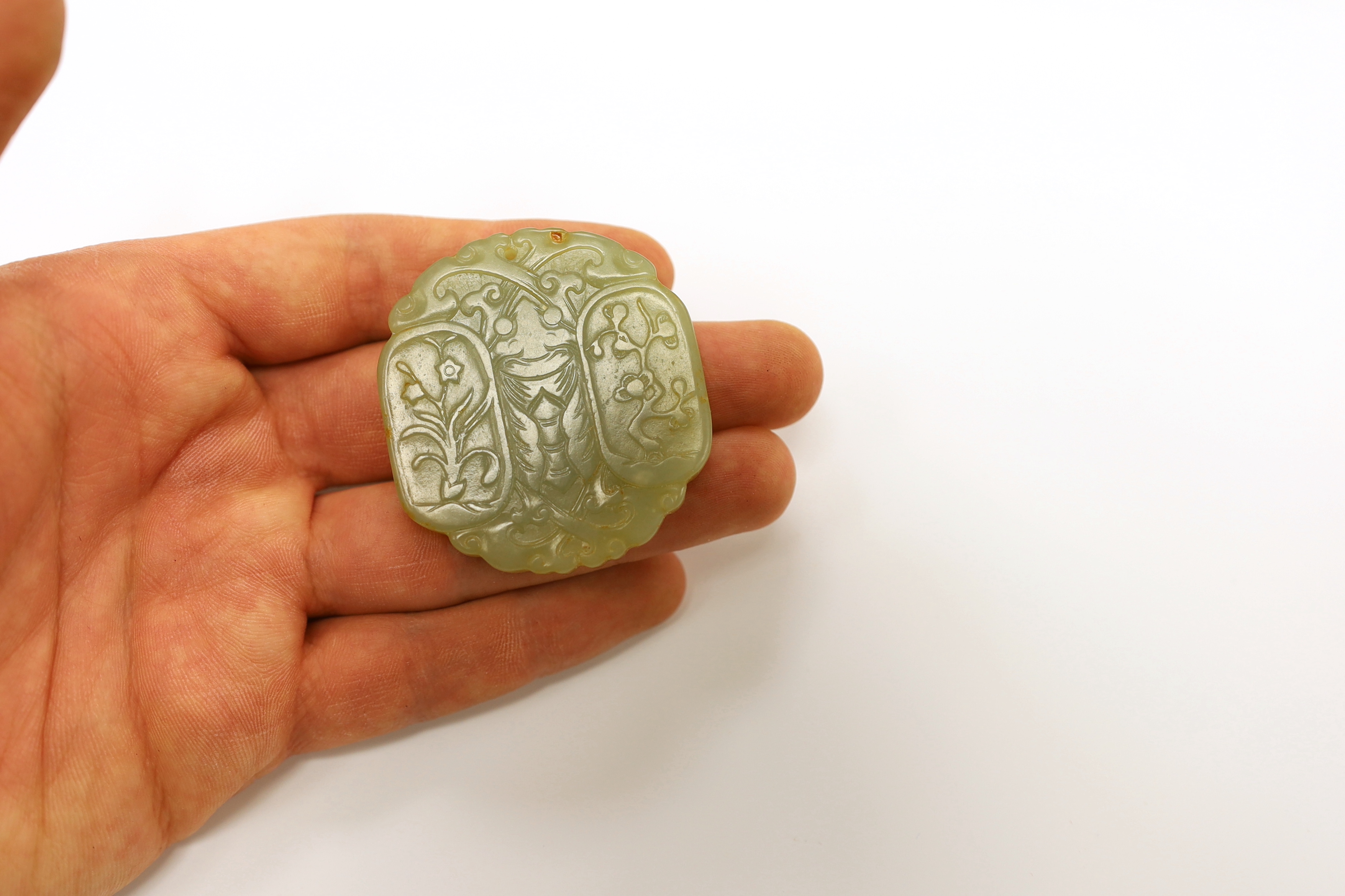 A Chinese carved jade pendant and another carving of a recumbent lion dog, largest 5cm